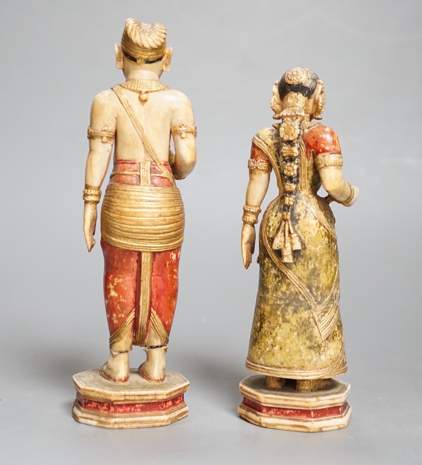 A pair of 18th century painted carved Indian ivory figures, male 7.6cm high female: 5.5cm high